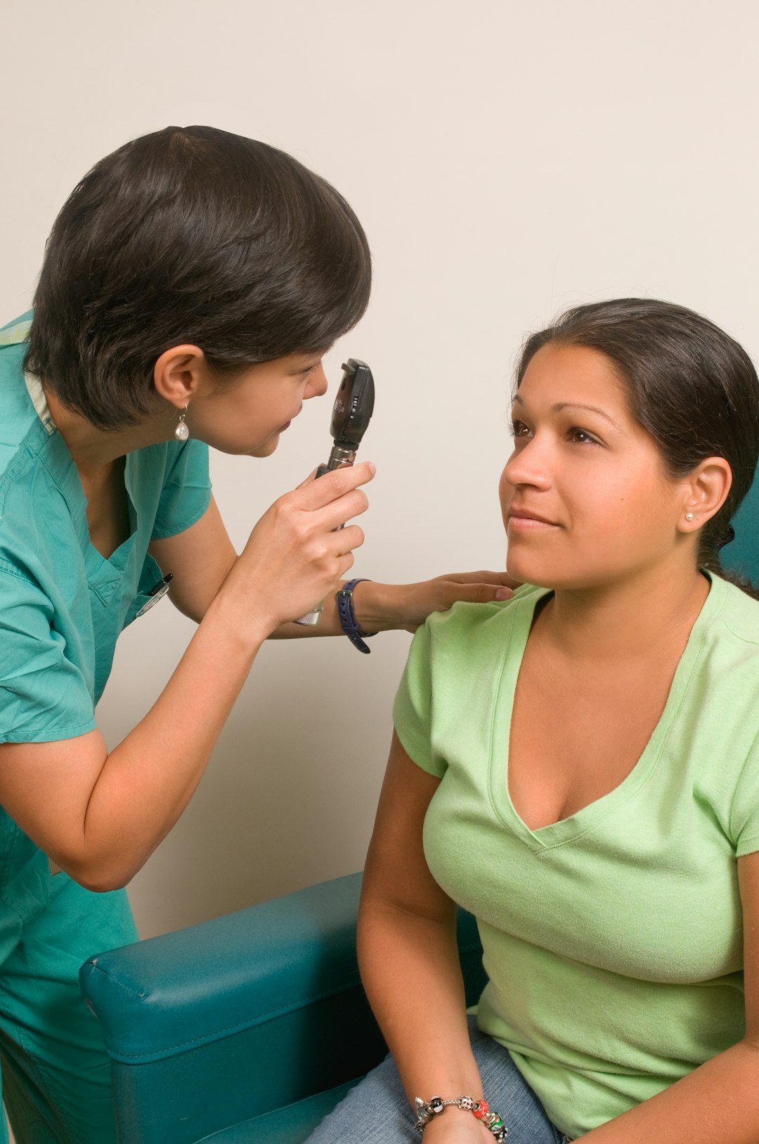 An ophthalmologist examining a patients eye with an ophthalmoscope